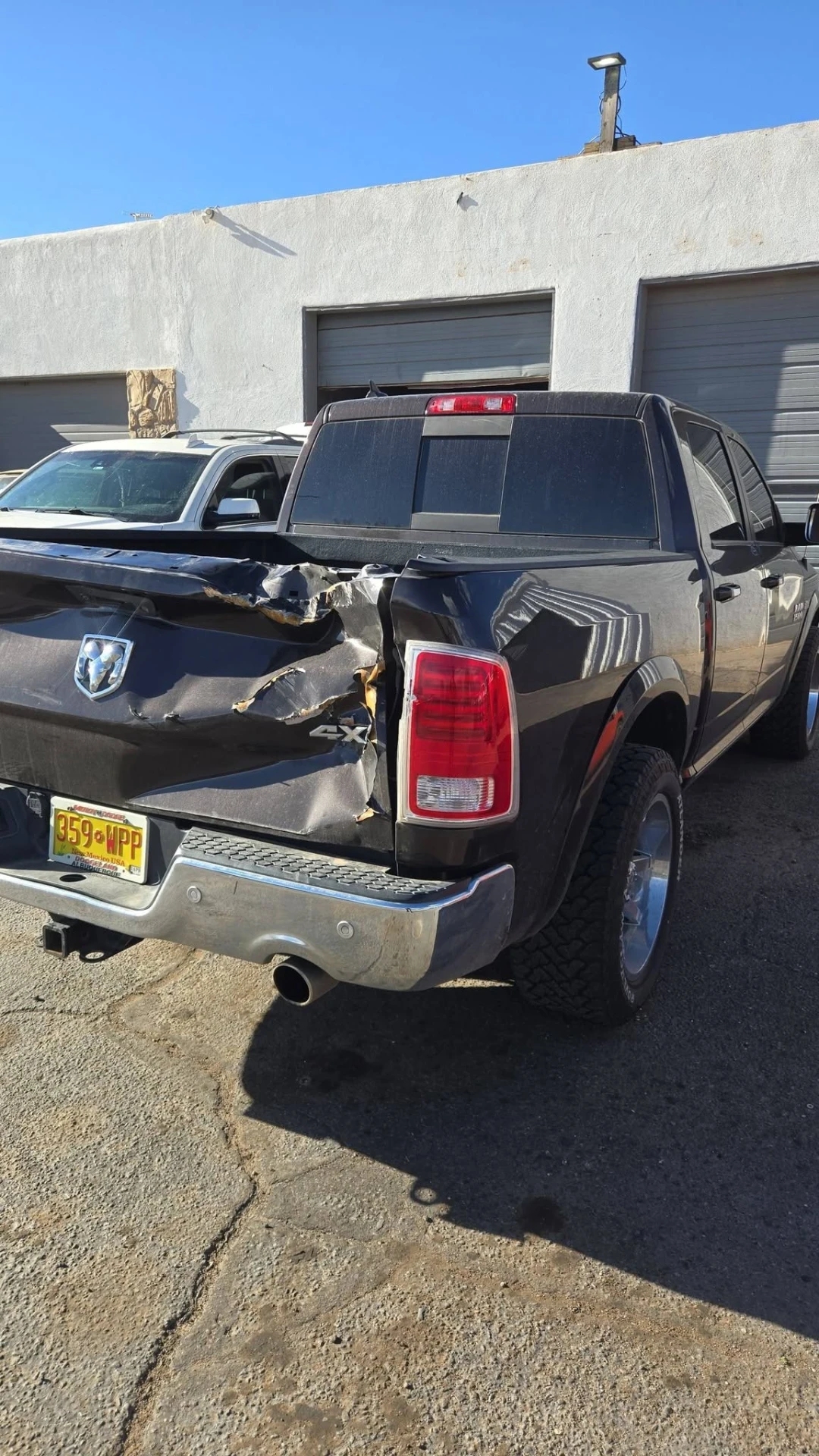 Black Ram 1500 with crushed rear bedside and tailgate before repair