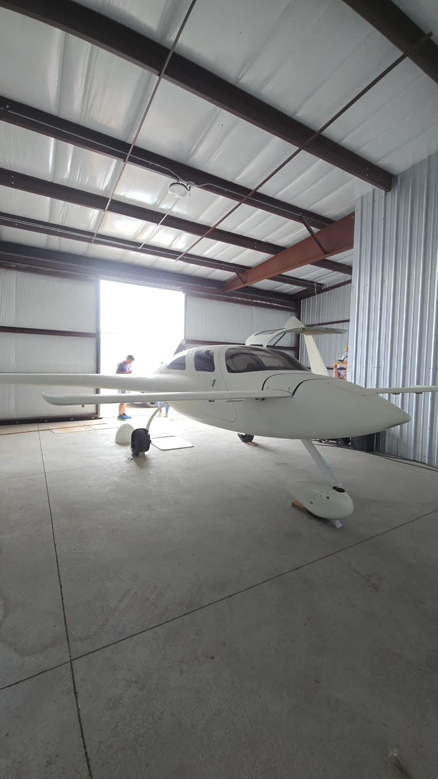 Velocity XL experimental aircraft in primer white inside a hangar before custom paint